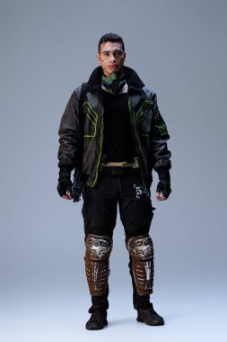 Gri üzerinde duran yakışıklı çift ırklı siber punk oyuncusu  