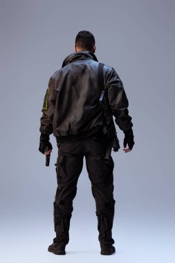 Siber punk oyuncusunun elinde silah tutarken ve gri üzerinde dikilirken  