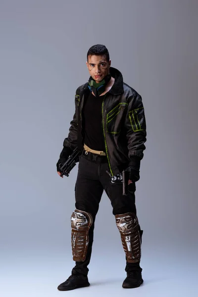 Mixed Race Cyberpunk Player Mask Holding Gun While Standing Grey — Stock Photo, Image