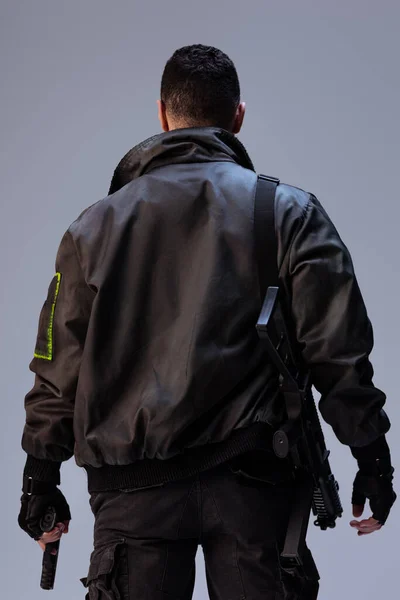站在灰色的时候拿着枪的网络朋克玩家的背景图 — 图库照片