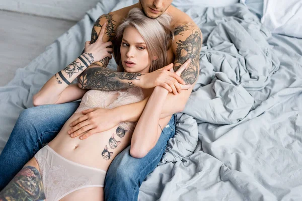 Muskulöser Mann Jeans Umarmt Tätowierte Frau Unterwäsche Auf Dem Bett — Stockfoto
