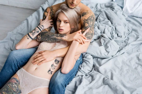 Homem Muscular Jeans Abraçando Mulher Tatuada Roupa Interior Cama — Fotografia de Stock