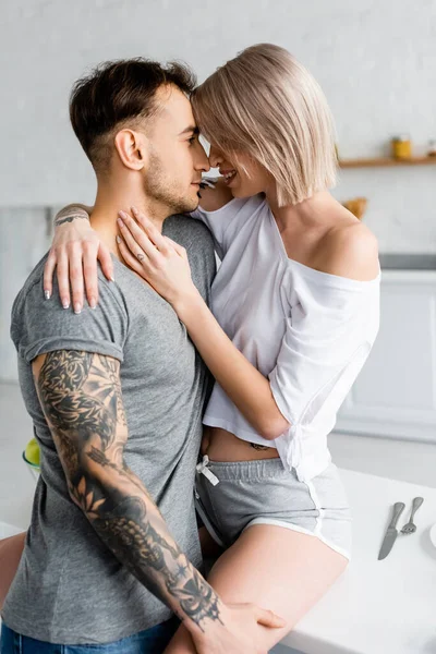 Side View Tattooed Man Embracing Smiling Girlfriend Kitchen Table — Stock Photo, Image