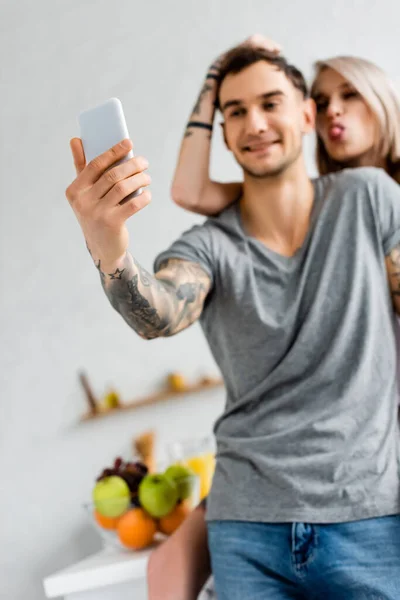 Gülümseyen Adamın Akıllı Telefonuyla Selfie Çektiği Seçmeli Odak Noktası Mutfaktaki — Stok fotoğraf