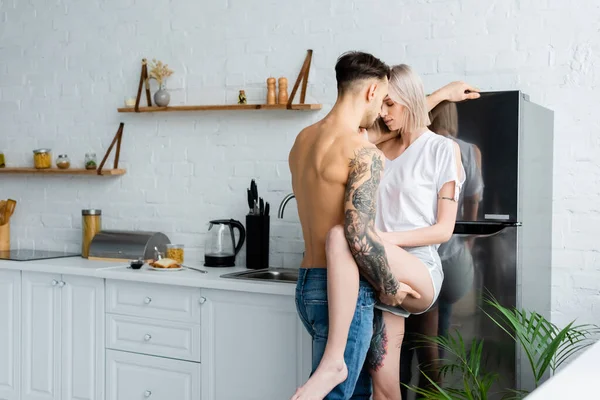 Shirtless Uomo Tatuato Toccare Gamba Bella Fidanzata Vicino Frigorifero Cucina — Foto Stock