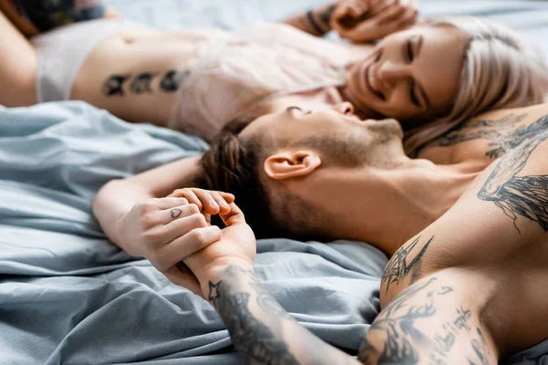 Selective Focus Muscular Tattooed Man Smiling Beautiful Girlfriend Lingerie Bed — Stock Photo, Image