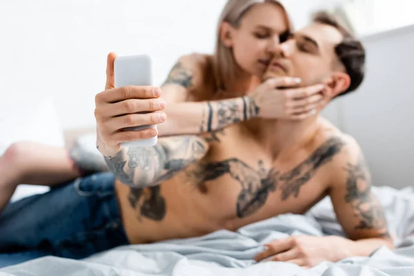 Enfoque Selectivo Chica Besando Novio Tatuado Tomando Selfie Con Teléfono — Foto de Stock