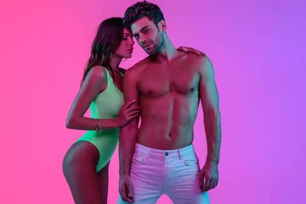 Seductive Girl Green Swimsuit Embracing Shirtless Man White Jeans Pink — Stock Photo, Image