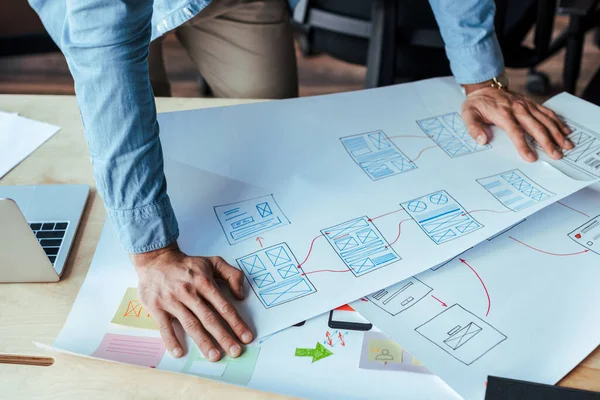 Masasında dokuma kağıtları olan UI tasarımcısının kırpılmış görünümü 