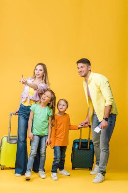 Bavulu, pasaportu ve sarı biletleri olan mutlu bir aile.