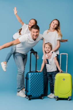 excited family of travelers with suitcases, passports and tickets on blue clipart