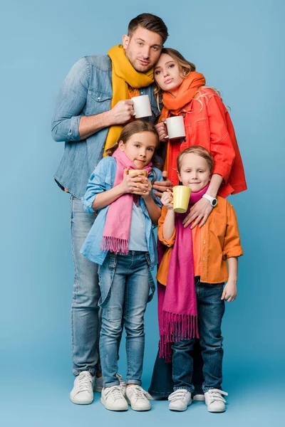 青い上に熱い飲み物でカップを持っている子供たちと家族は — ストック写真