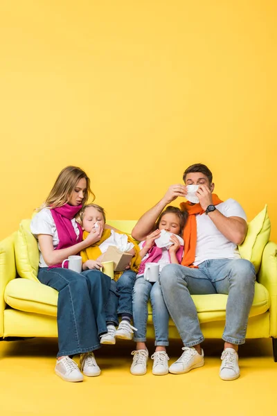 Chora Rodzina Serwetkami Katar Nosy Siedząc Kanapie Żółtym — Zdjęcie stockowe