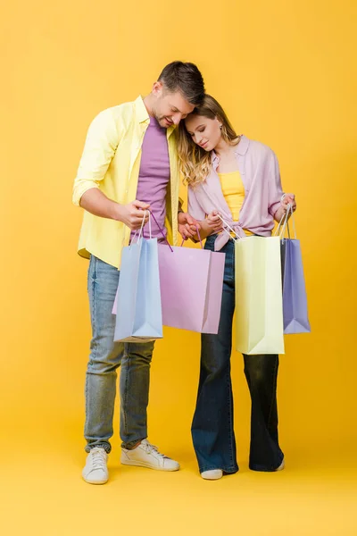 Belo Casal Feliz Olhando Sacos Compras Amarelo — Fotografia de Stock