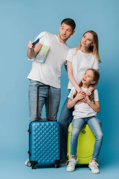 父母和震惊的女儿 带着旅行袋 地图和蓝色护照 — 图库照片