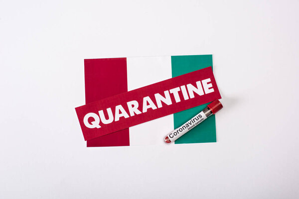 top view of test tube with blood sample near quarantine lettering on italian flag on white 
