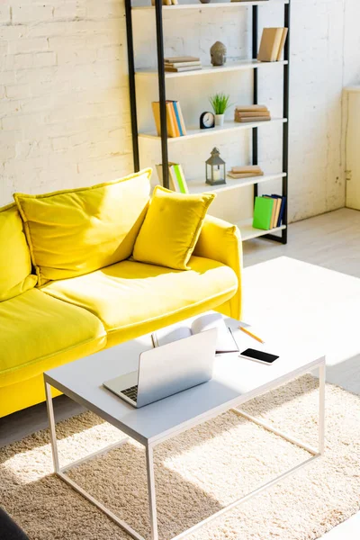 Pokój Dzienny Żółtą Sofą Półką Stołem Laptopem Smartfonem Notatnikiem Świetle — Zdjęcie stockowe