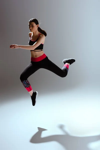 Chica Atractiva Ropa Deportiva Saltando Gris — Foto de Stock