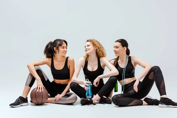 Meninas Multiculturais Felizes Sentadas Com Equipamentos Esportivos Branco — Fotografia de Stock