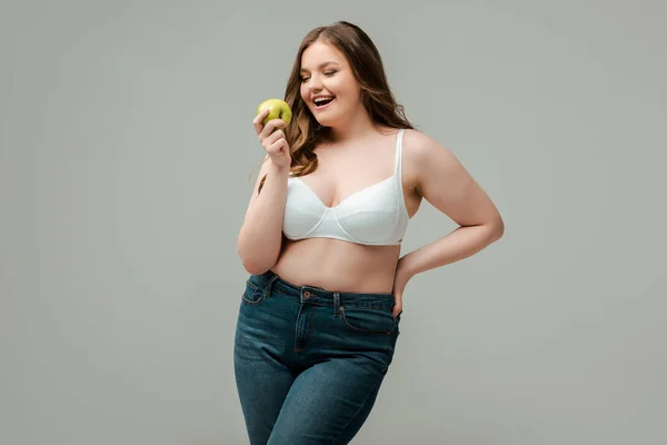Весела Жінка Плюс Розмір Джинсах Бюстгальтер Тримає Яблуко Ізольовано Сірому — стокове фото