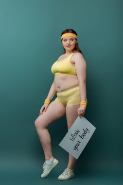 Artı, plaketi olan sporcu kadın. Yeşil arka plana bakan vücudunun harfleri.