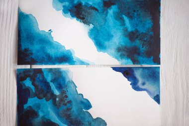 Top view of paper with Japanese painting with blue watercolor on wooden background clipart