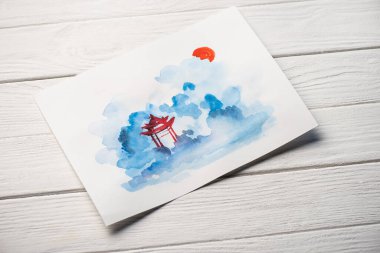 Tahta arka planda tapınağı olan Japon resimli kağıdın yüksek açılı görüntüsü.
