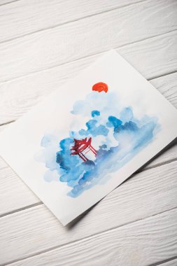 Tahta yüzeyde tapınağı olan Japon resimli kağıdın yüksek açılı görüntüsü.