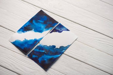 Ahşap zemin üzerinde açık mavi suluboya olan Japon resimli yüksek açılı kağıt manzarası.