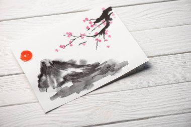 Japon resimli kağıdın yüksek açılı görüntüsü güneş, Sakura dalları ve tahta arka planda gri tepe.