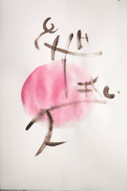 Pembe çemberin üzerinde hiyeroglifler olan Japon resimli kağıdın üst görüntüsü.