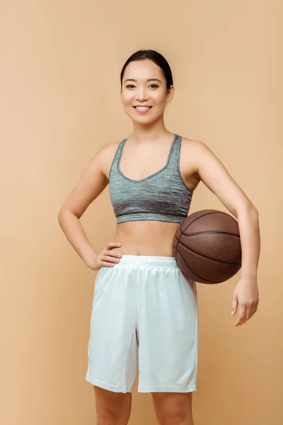 Asiática Deportista Con Mano Cadera Bola Sonriendo Mirando Cámara Aislada — Foto de Stock
