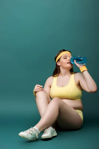 Size Sportswoman Crossed Legs Closed Eyes Drinking Water Green — Stock Photo, Image