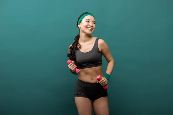 Feliz Asiático Sportswoman Con Dumbbells Sonriendo Aislado Verde — Foto de Stock