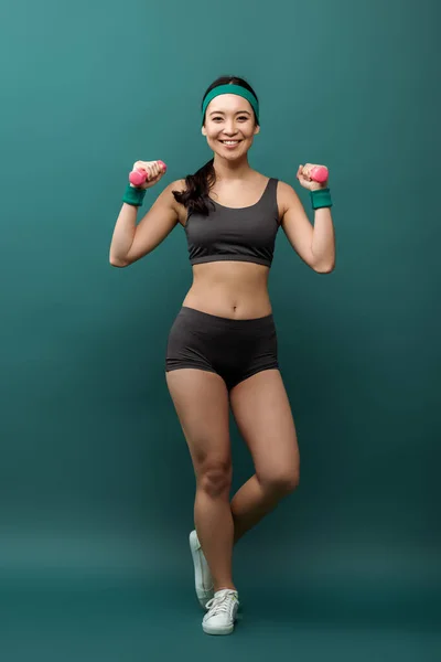 Happy Asian Sportswoman Training Dumbbells Smiling Looking Camera Green Background — Stock Photo, Image