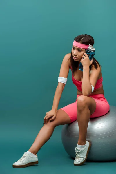 Zamyšlená Africká Americká Sportovkyně Sportovní Láhví Fitness Míč Zeleném Pozadí — Stock fotografie