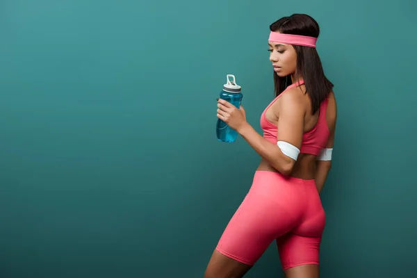 Αφροαμερικάνα Αθλήτρια Ροζ Αθλητικά Ρούχα Κοιτάζοντας Αθλητικό Μπουκάλι Απομονωμένο Πράσινο — Φωτογραφία Αρχείου