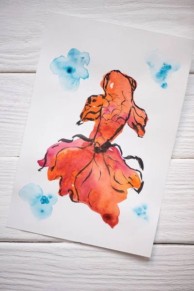 Top view of paper with Japanese painting with orange fish on wooden background