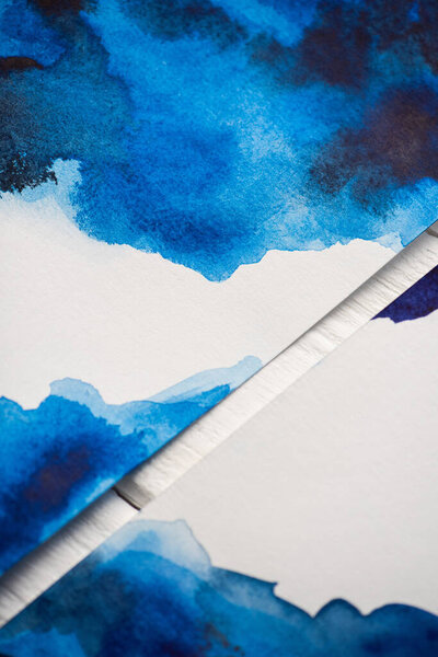 High angle view of paper with japanese painting with blue watercolor on wooden background