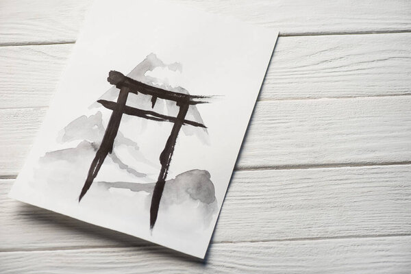 Top view of paper with japanese painting with hieroglyph on wooden background