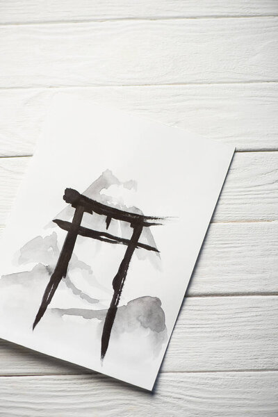 Top view of paper with japanese painting with black hieroglyph on wooden background