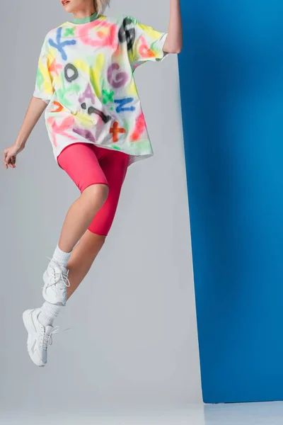 Modische Frau Springt Neonpinkfarbenen Fahrradhosen Und Buntem Shirt Auf Grau — Stockfoto