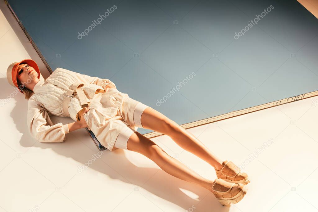 attractive young woman posing for future fashion shoot on beige and blue