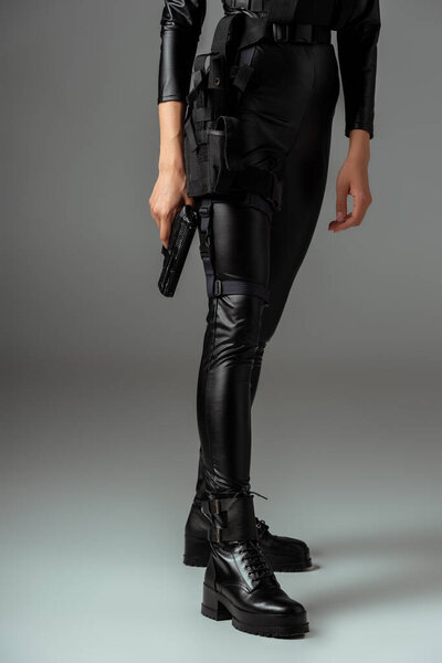 partial view of  futuristic african american woman in glasses with gun on grey