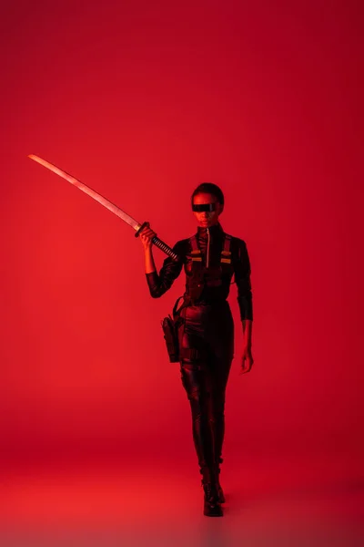 Futuristic African American Woman Glasses Walking Sword Red Background — Stock Photo, Image