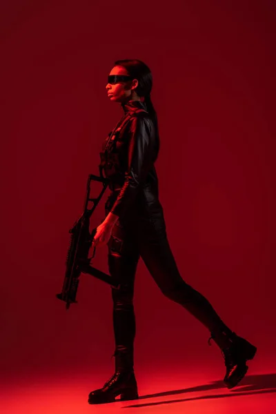 Futuristic African American Woman Glasses Walking Assault Rifle Red Background — Stock Photo, Image