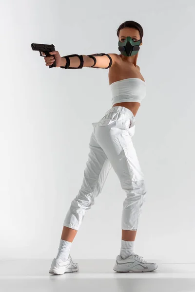 Futuristic African American Woman Safety Mask Aiming Gun White Background — Stock Photo, Image