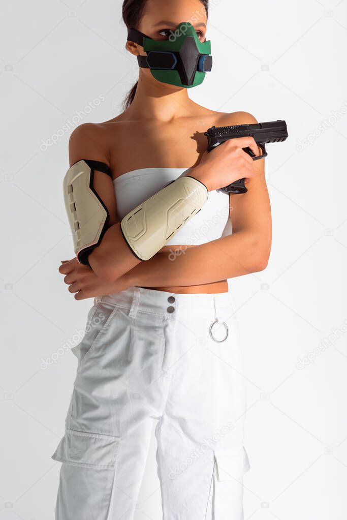 futuristic african american woman in safety mask with gun isolated on white