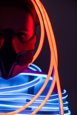 cropped view of futuristic african american woman in respirator and neon lighting clipart