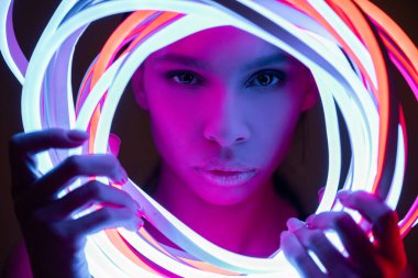 portrait of futuristic african american woman in neon lighting clipart
